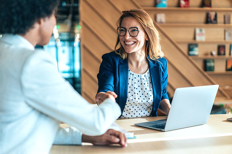 two women shaking hands at a job interview