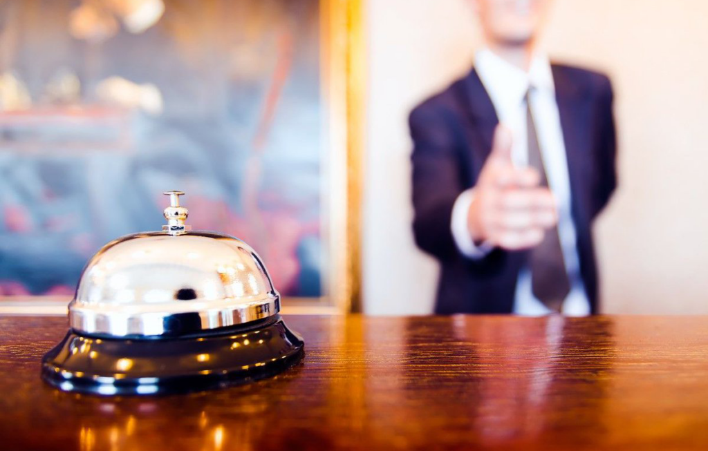 closeup of front desk bell with concierge in background