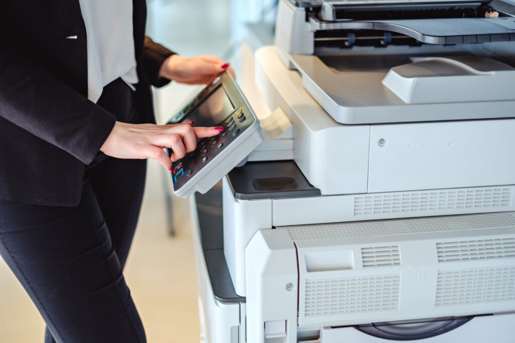 Woman presses a button on a multifunction printer